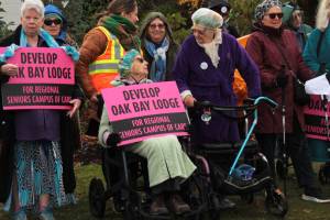 Joan Greatbatch, centre, and her neighbour Anne Griffith (in purple) take centre stage during a walk to call for action on the former Oak Bay Lodge land. The Dec. 6 walk to municipal hall, organized by Action Oak Bay, seeks a campus of eldercare at the Cadboro Bay Road site. (Christine van Reeuwk/Oak Bay News)